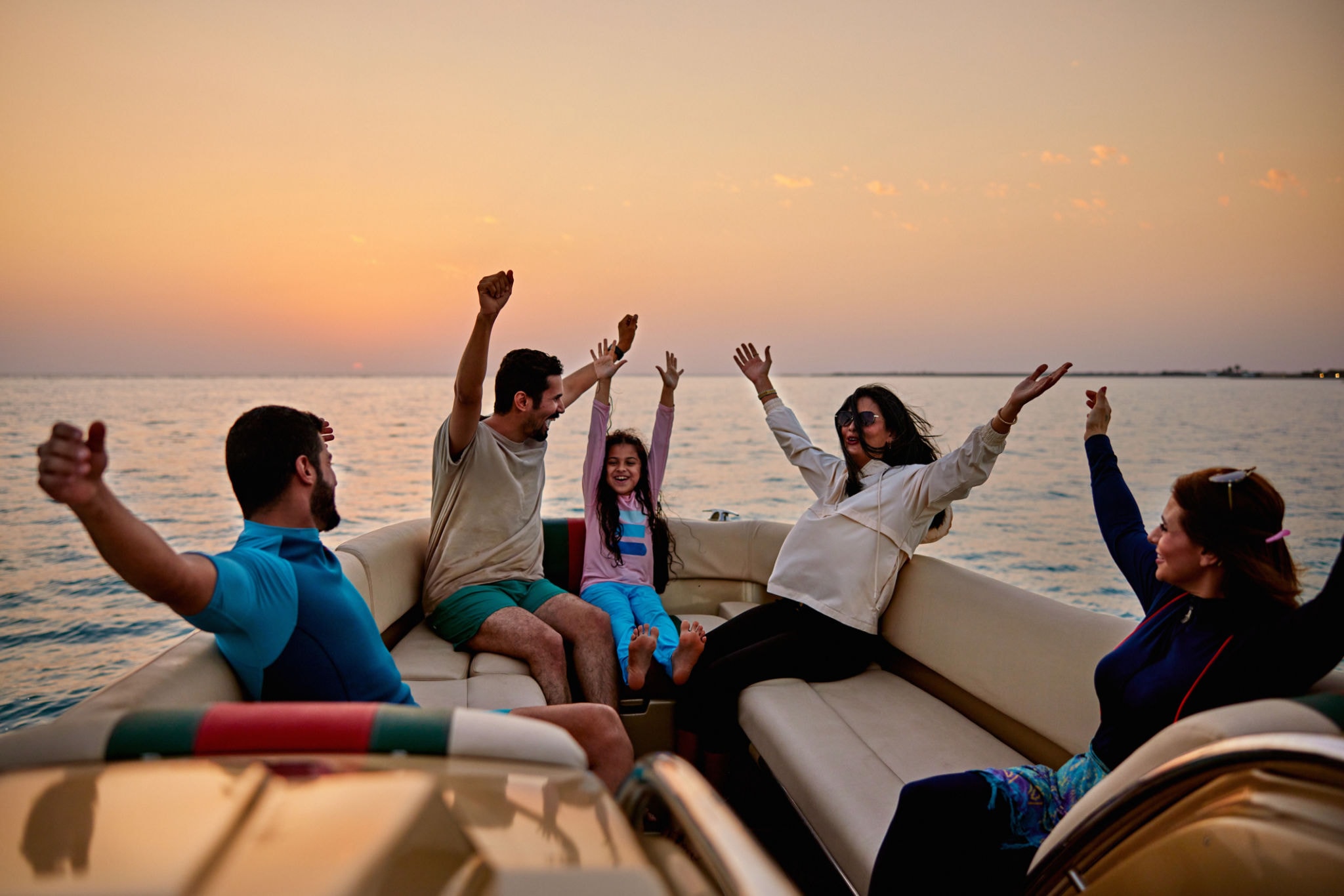 Family celebrating on a boat at sunset