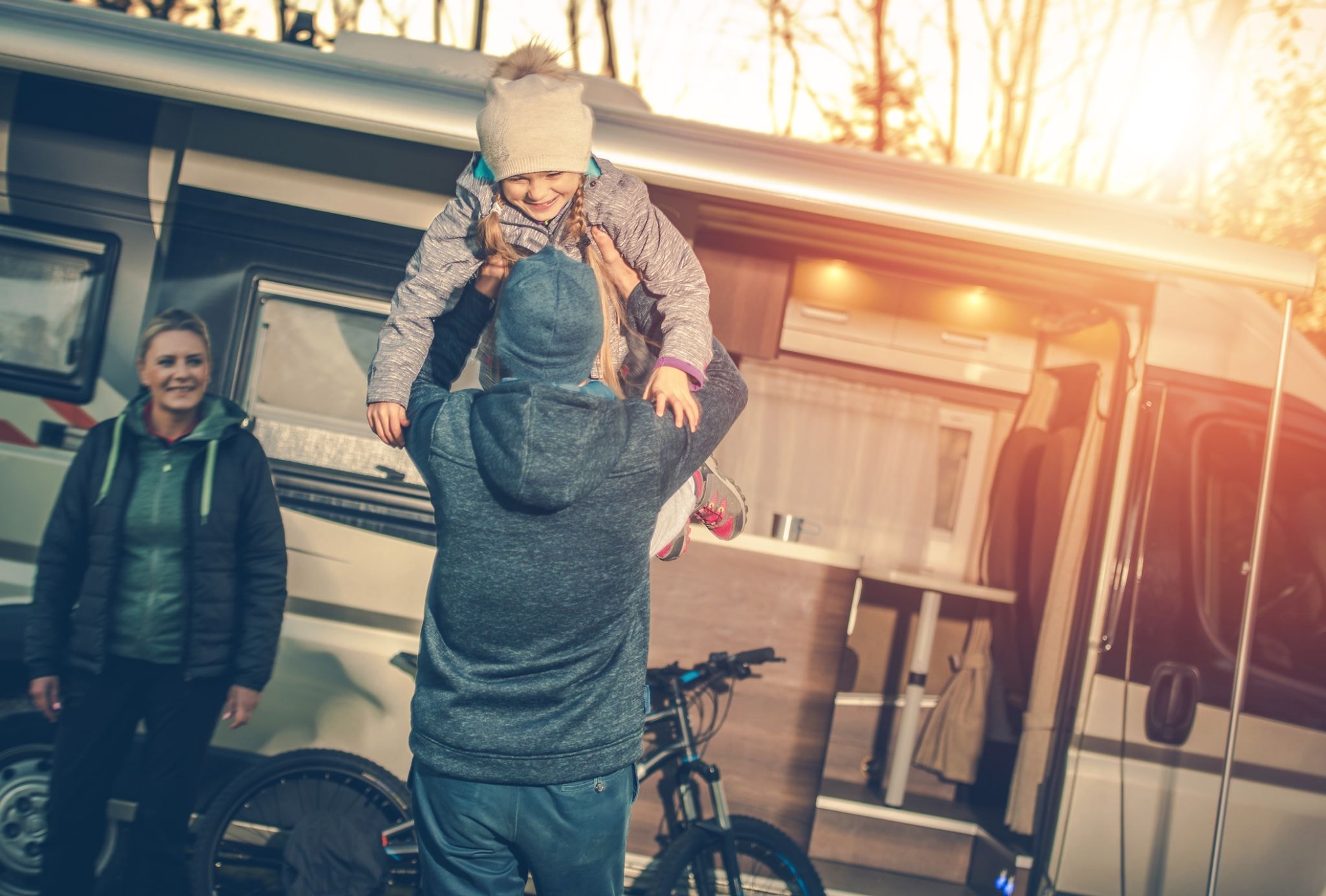 Family playing outside their RV at a campsite